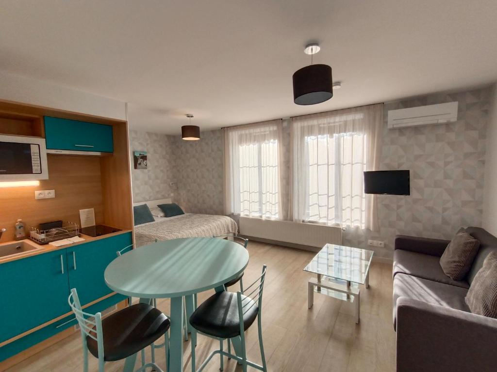 a small living room with a table and a couch at Appart'Hotel Parc Johan in Chauffailles
