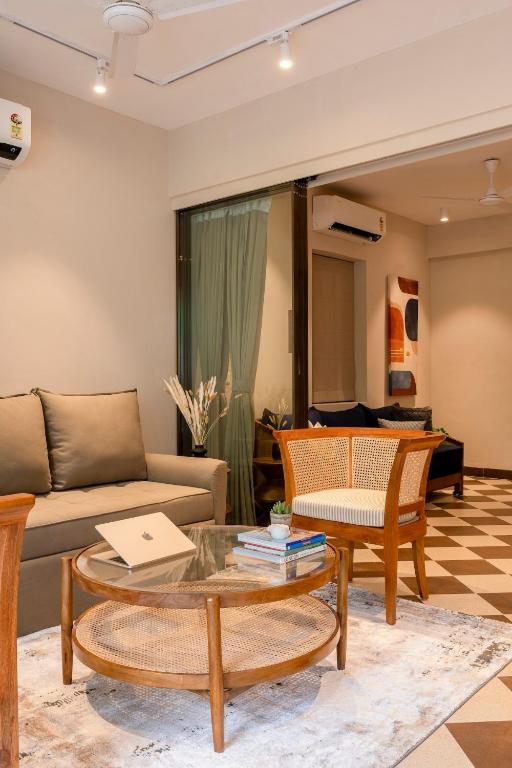 a living room with a couch and a table at Staymaster Solintra - Serviced Apartment - Pool in Nerul