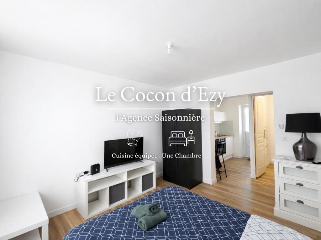 a white bedroom with a bed and a desk at Le Cocon d'Ezy in Ézy-sur-Eure