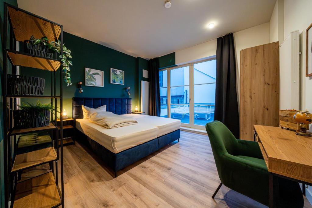 a bedroom with a bed and a green accent wall at Pacmans Penthouse in Leipzig