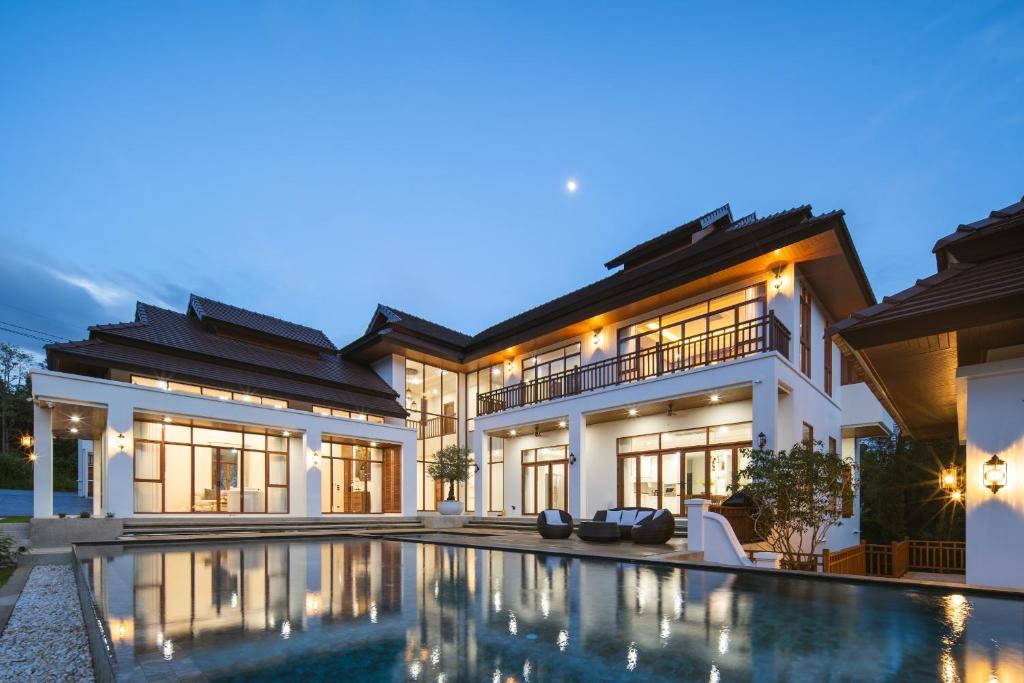 a villa with a swimming pool at night at Spoonamore Villa in Hang Dong