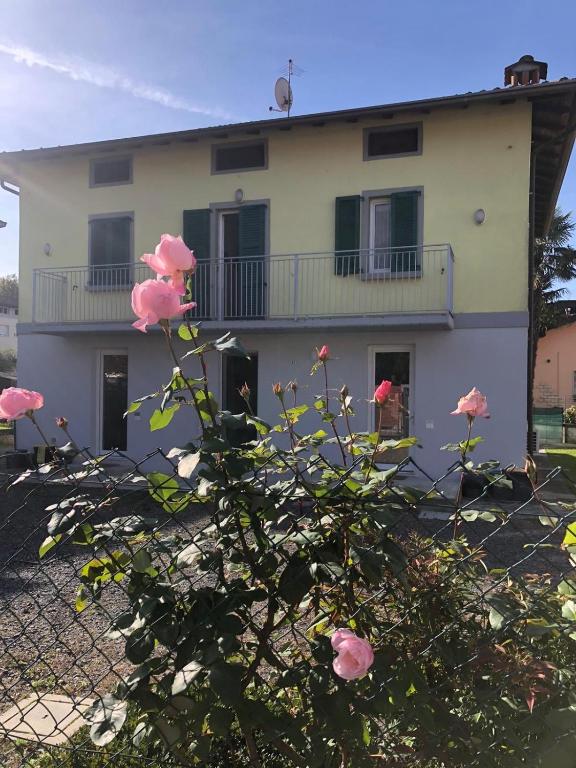 a house with pink roses in front of it at Appartamento DANTE in Pisogne