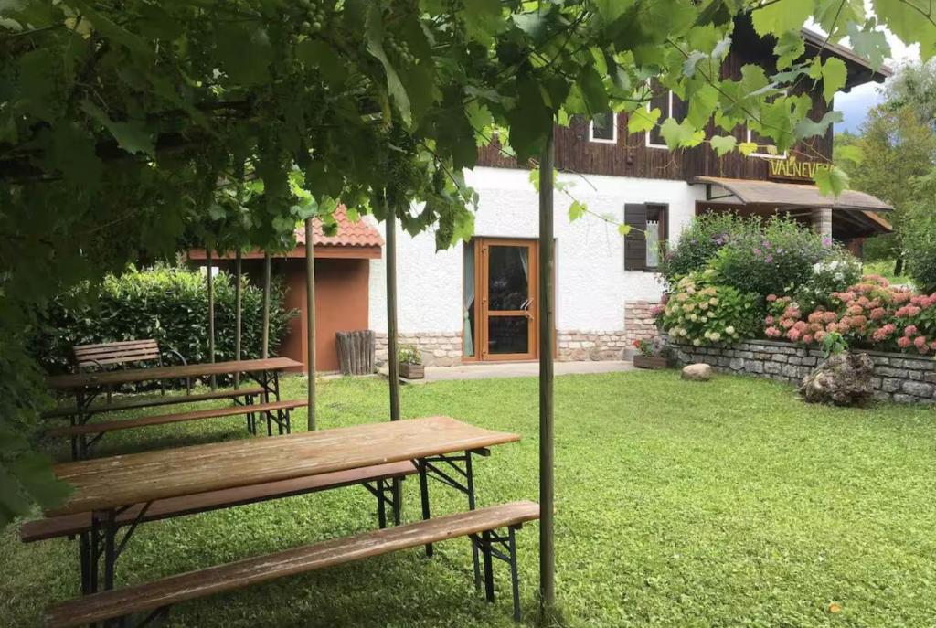 Zwei Bänke stehen im Gras vor einem Haus in der Unterkunft Chalet ValNevera in Arsiè