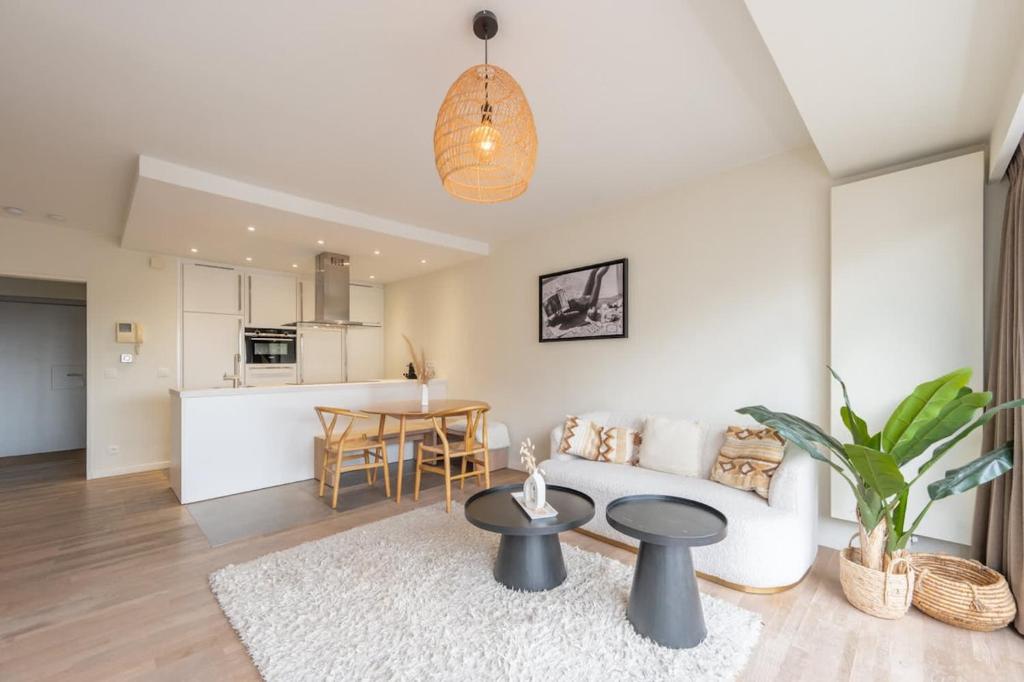 a living room with a couch and a table at Modern Cozy Studio - Prime location Knokke in Knokke-Heist