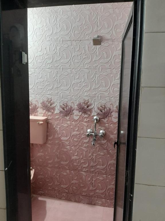 a bathroom with a toilet and a pink wall at Satyam in Jāmb