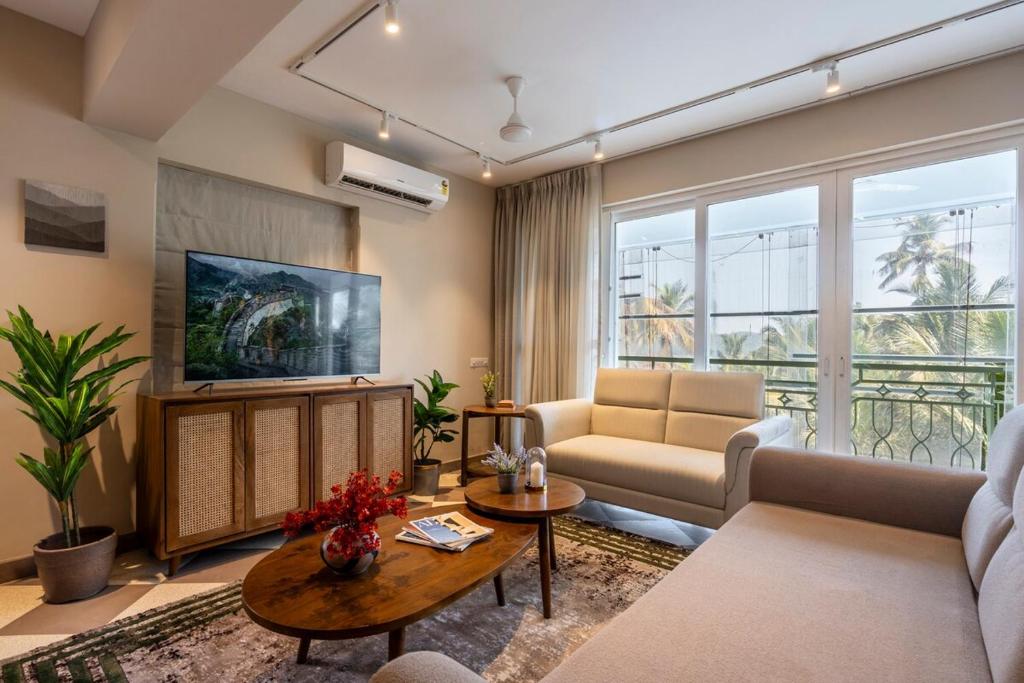 a living room with a couch and a tv at Staymaster Solintra C301 - Pool in Nerul