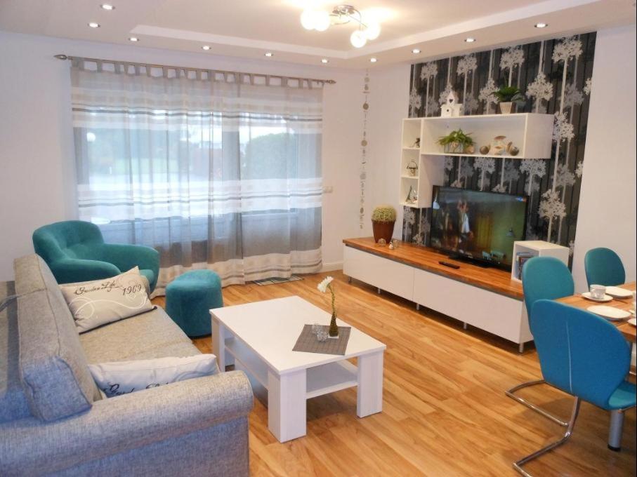 a living room with a couch and a tv at Golfresidenz B 007 in Grömitz