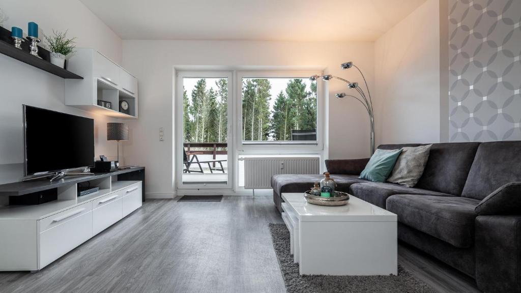 a living room with a couch and a tv at Golfresidenz B 106 in Grömitz