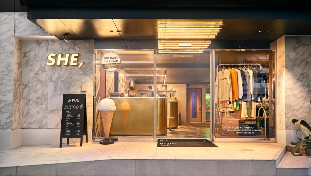 a store window of a clothing store with a sign at Hotel She, Kyoto in Kyoto