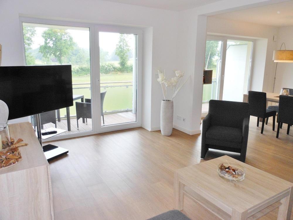 a living room with a table and a living room with a view at Golfresidenz D 1 03 in Grömitz