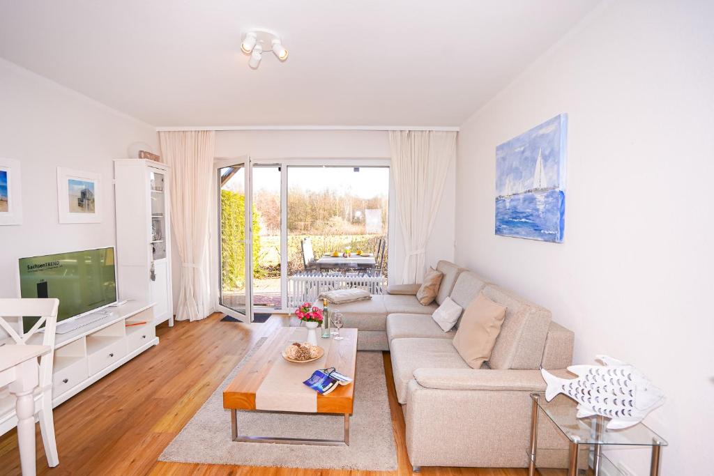 a living room with a couch and a tv at Golfresidenz B 010 Heimathafen in Grömitz