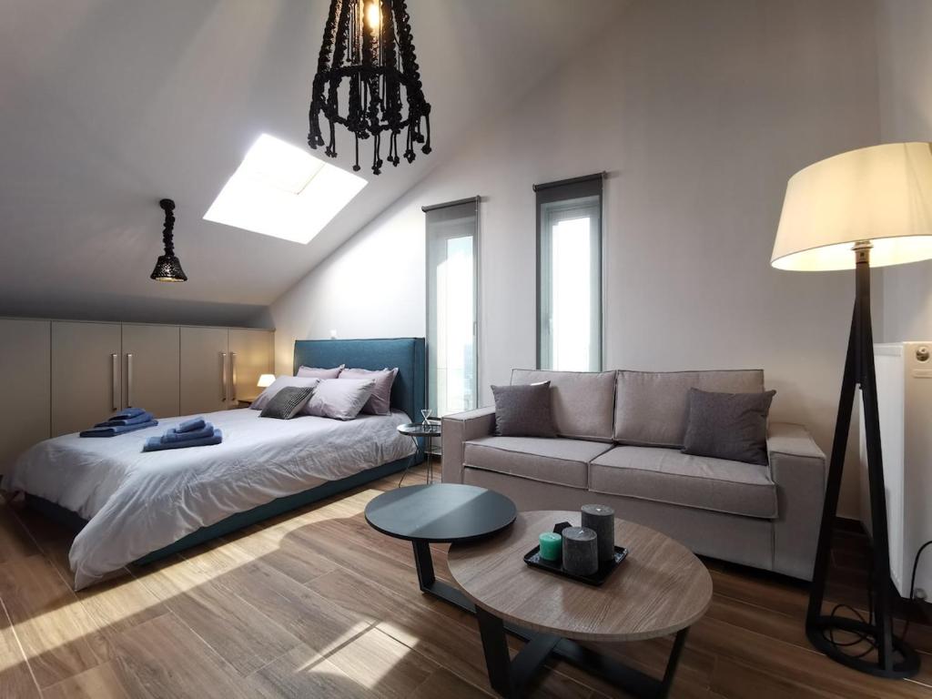 a bedroom with a bed and a couch and a table at Athenean Rooftop Nest in Athens