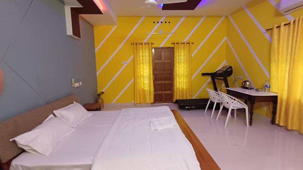 a bedroom with a bed and a desk and a table at Greeny Homestay in Cochin