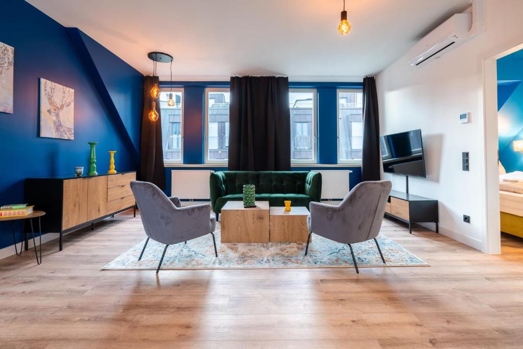 a living room with a green couch and chairs at Laras Loft in Leipzig