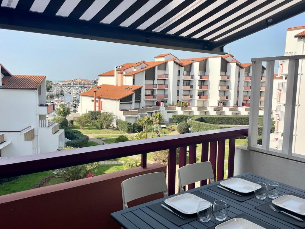 a table on a balcony with a view of a building at Appartement - Bonamour in Capbreton