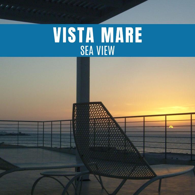 a pair of chairs sitting on a balcony with the sunset at Brezza Di Grecale in Trapani