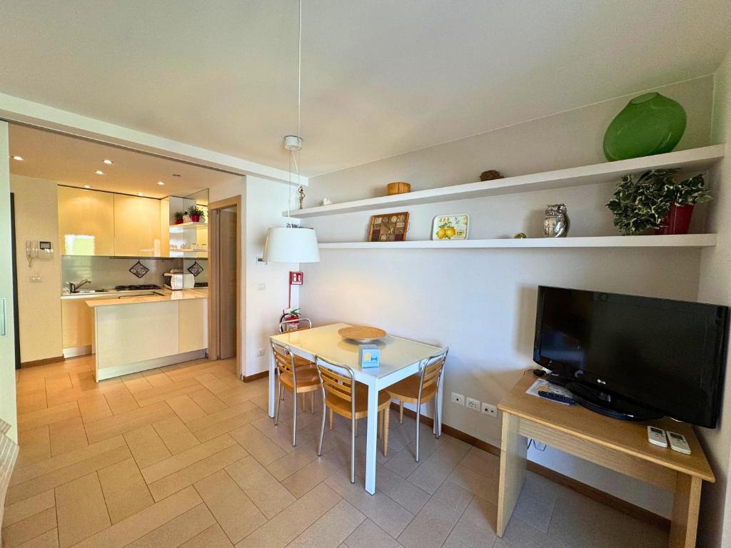 a kitchen and dining room with a table and a television at Appartamenti La Croma in Grado