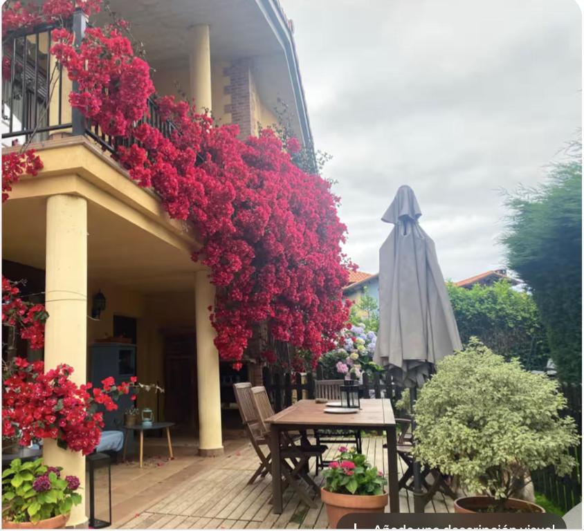 a patio with a table and an umbrella and flowers at La Venta in Arguedes