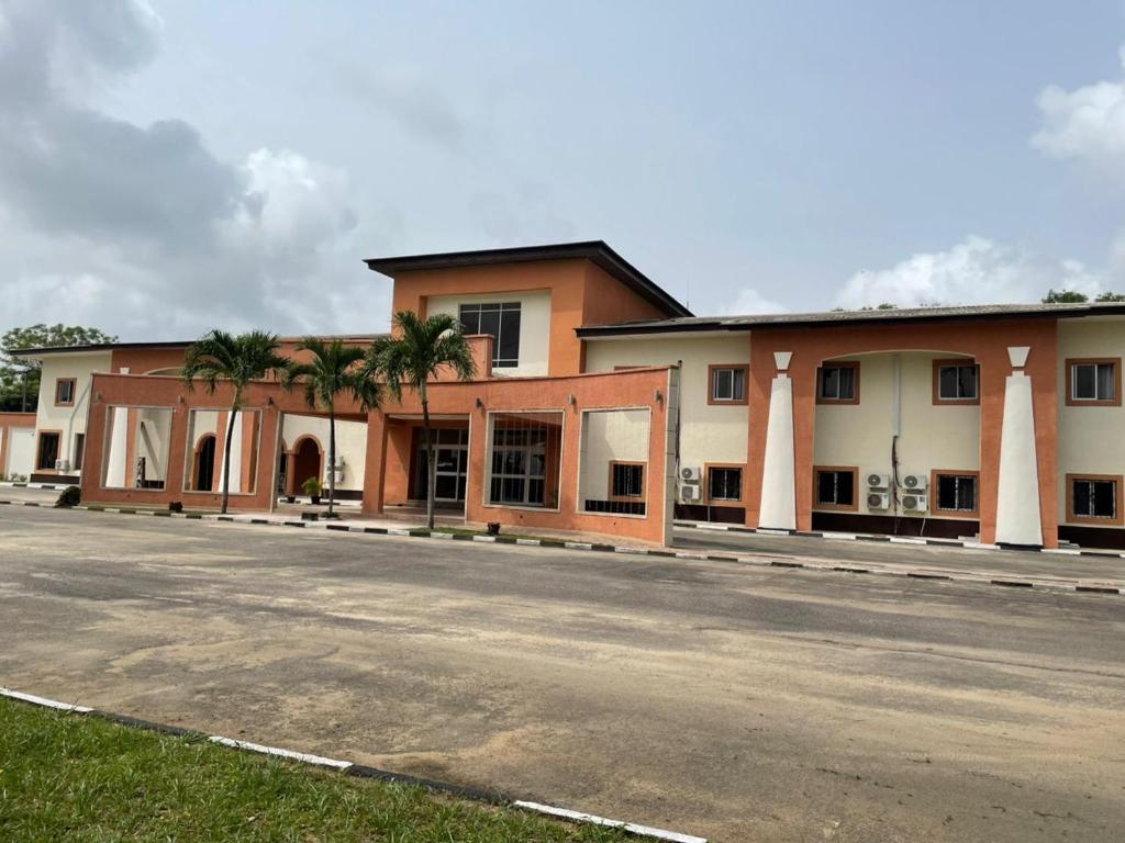 a building with palm trees in front of a street at Axari Hotel & Suites in Calabar