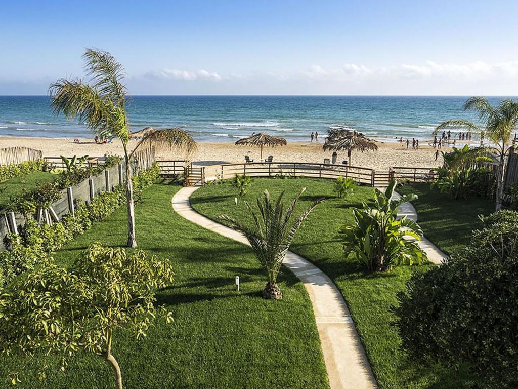 ドンナルカータにあるBelvilla by OYO Villa Muriel Morganaの砂浜へと続く遊歩道