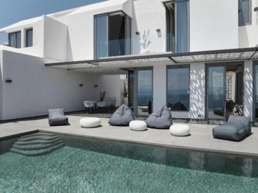 a house with a swimming pool in front of a house at Teria Collection in Porto Heli