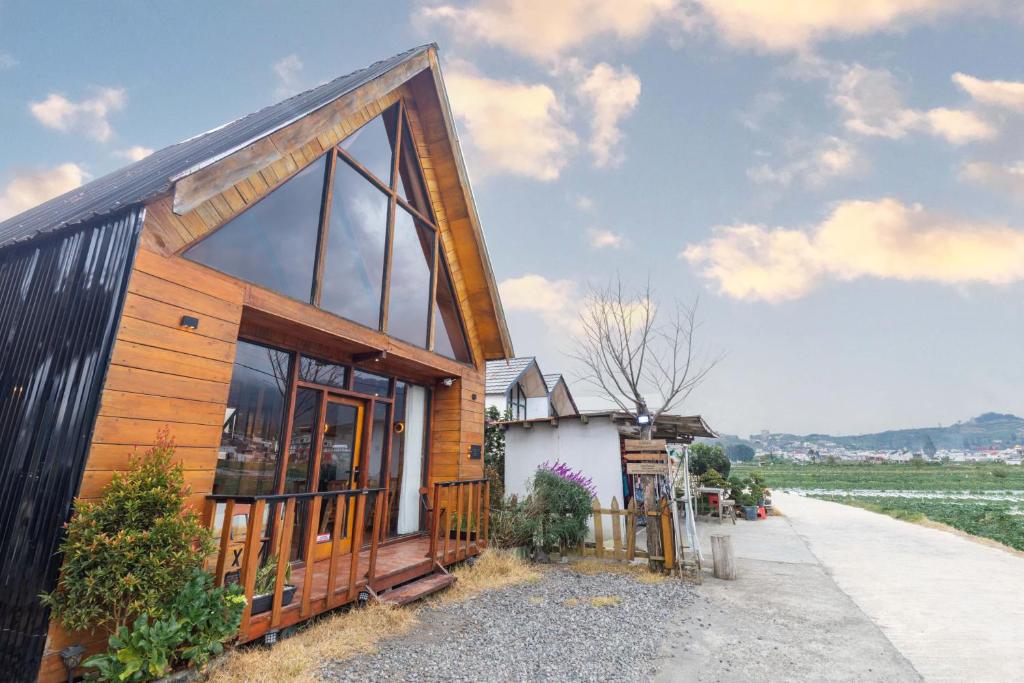 a small house with a black roof and windows at Cabin Linggayoni dieng in Diyeng