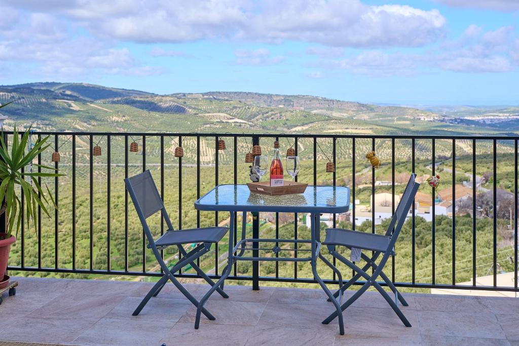 a table and chairs on a balcony with a view at Casa Rural Martemma in Zuheros