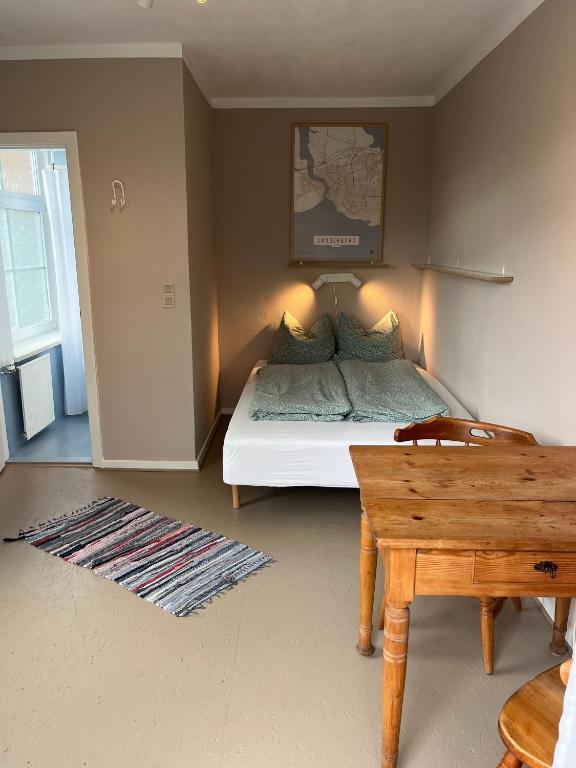 a small bedroom with a bed and a table at Rinkenæshus Das kleine Zimmer in Gråsten