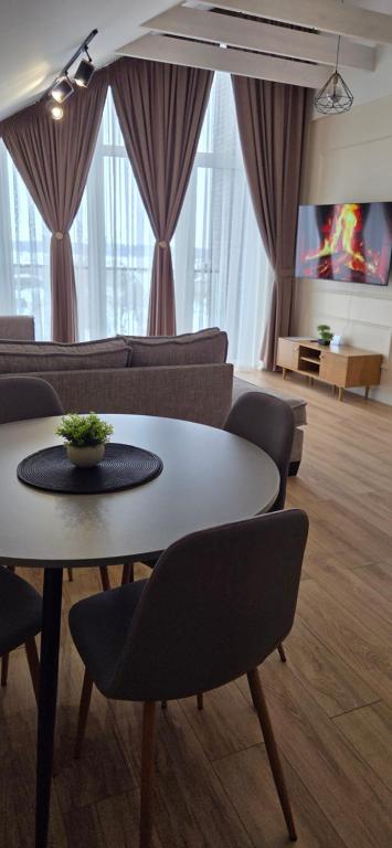 a living room with a table and chairs and a couch at Žvejų gatvė 1-2 in Telšiai