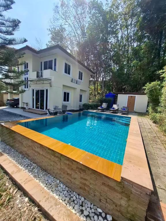 a villa with a swimming pool in front of a house at Private Pool Villa , 4BR, Fast WiFi, BBQ Garden in Ban Dan Mai
