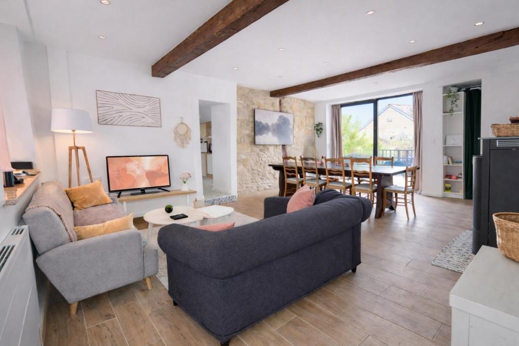 a living room with two couches and a dining room at Escapade de Pierrefonds - maison T4 vue château in Pierrefonds