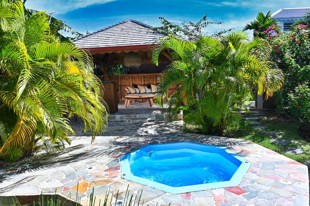 a small swimming pool in the middle of a yard at Cottage Vanda in Le Moule