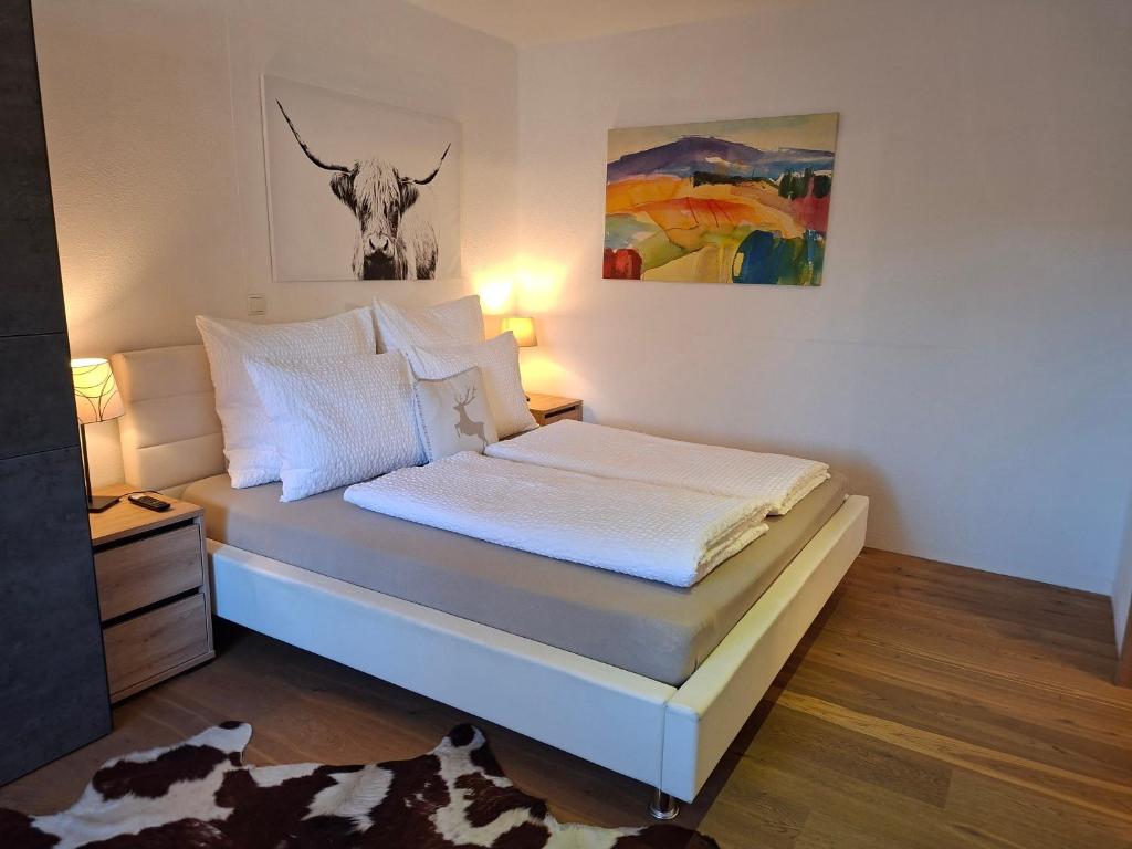 a bedroom with a bed with a cow picture on the wall at Haus Miriam in Mieming