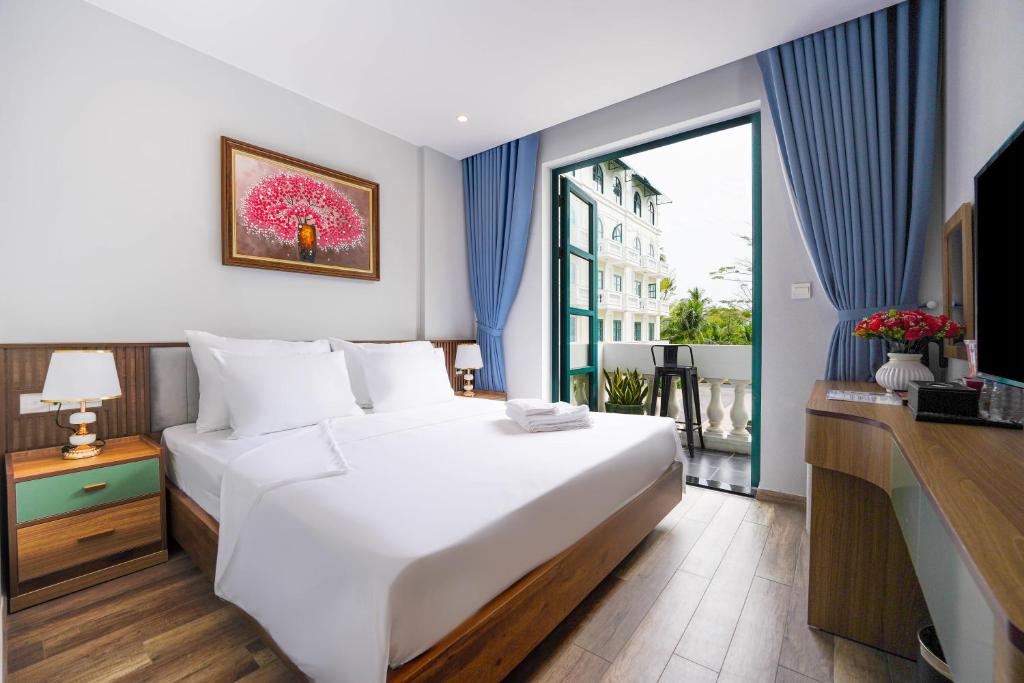 a bedroom with a large white bed and a window at Leono Coast Beach Hotel Phu Quoc in Phú Quốc