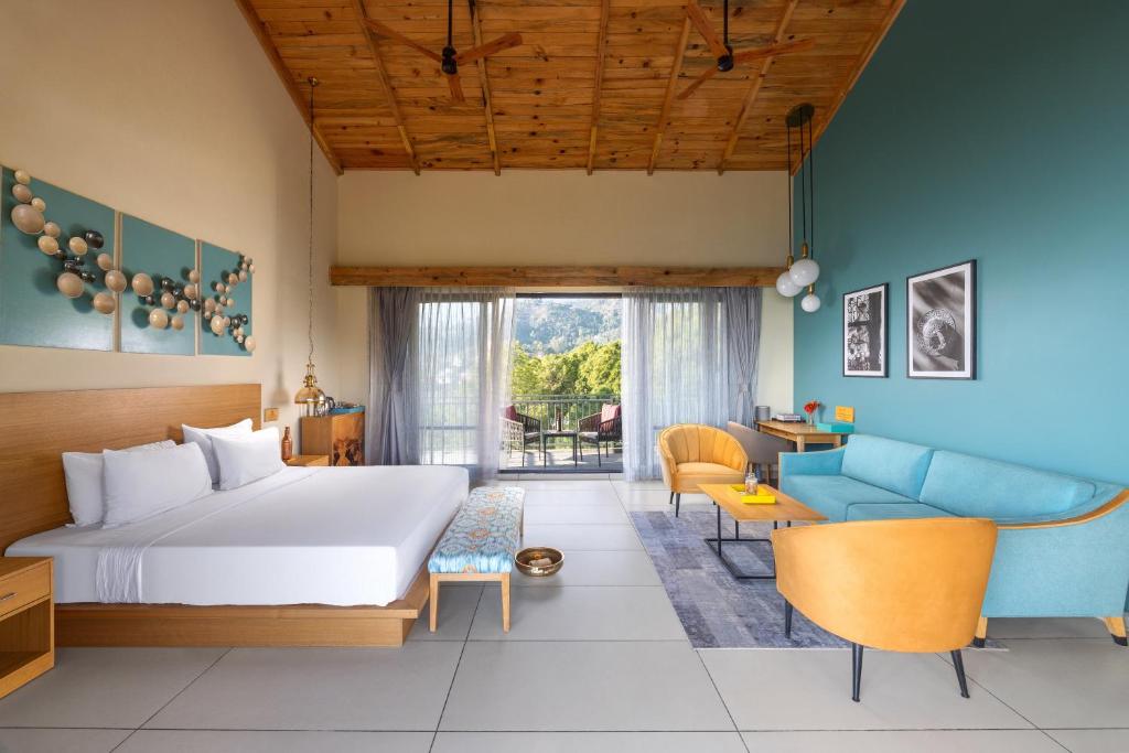 a bedroom with a bed and a living room at Rakkh Resort in Pālampur