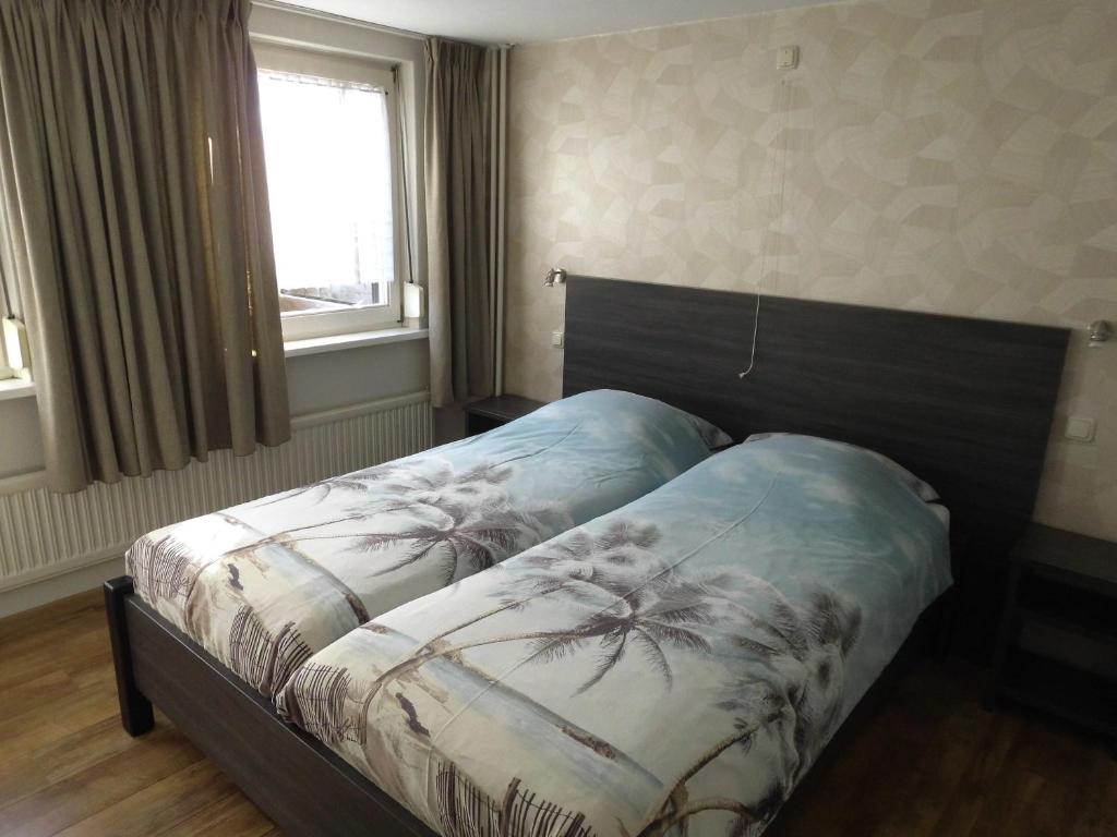 a bedroom with a bed with a blanket on it at Welca in Baarlo