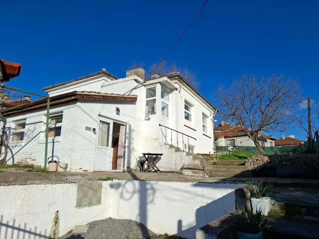 a white house with a fence in front of it at Bellas place in Yambol