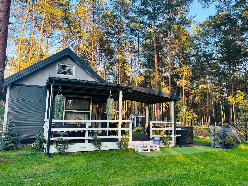a tiny house in the middle of a yard at CzarnyGaj in Gaj