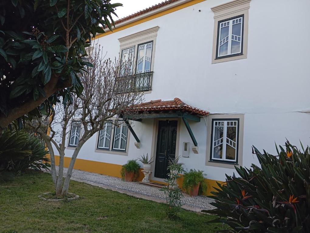a white house with black windows and a door at St Mary House in Tomar