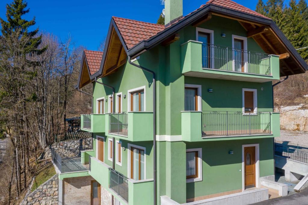 a green building with balconies on the side at Green house in Mezzaselva
