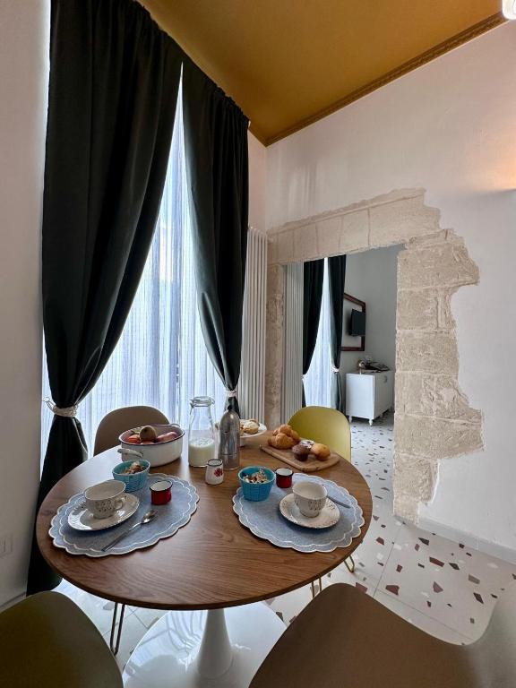 a dining room with a wooden table and chairs at Convers'Amo Home in Conversano