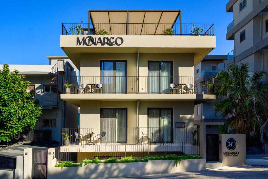 a building with a sign that reads mazquez at Monarco Executive Rooms in Rhodes Town