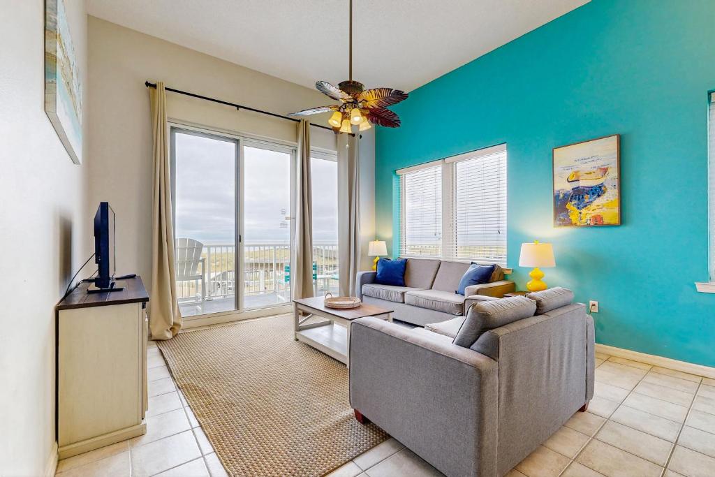 a living room with a couch and a tv at Beachfront Condo with amazing views shared pool and beach access in Navarre