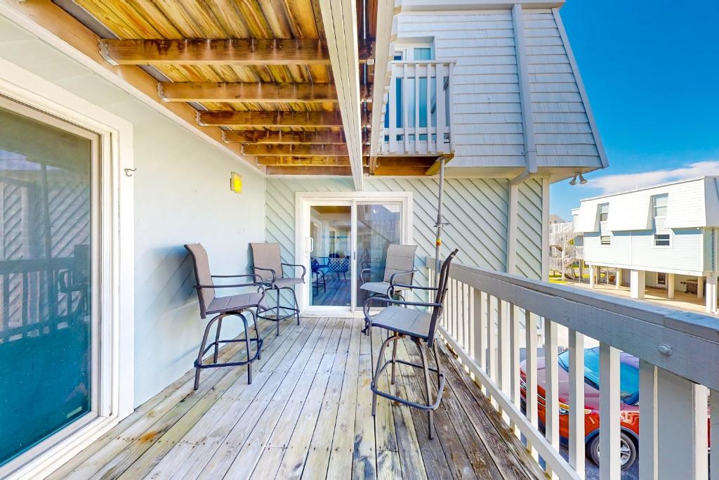 a porch with chairs on a house at Sound-Side Condo with Grill Deck & W&D and Shared Pool in Pensacola Beach