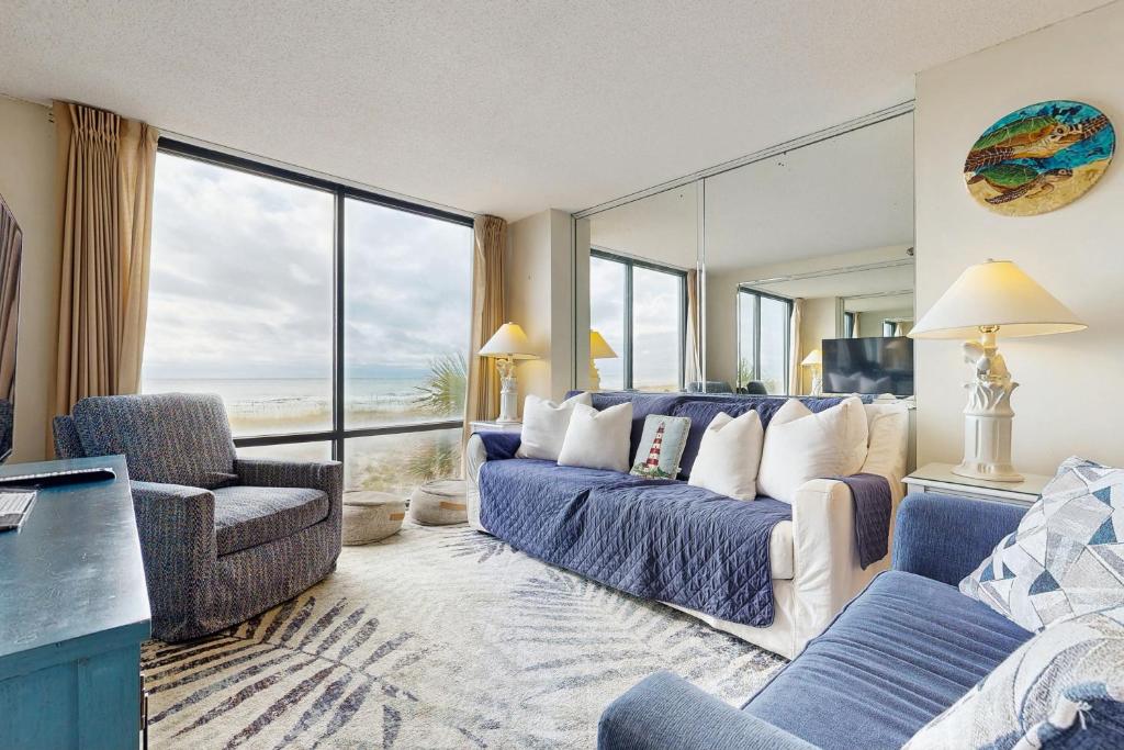 a living room with a couch and a large window at Beachfront condo shared pool large balcony and beach access in Navarre
