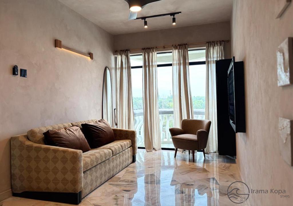 a living room with a couch and a chair at Irama Kopa - Glory Beach Resort in Port Dickson