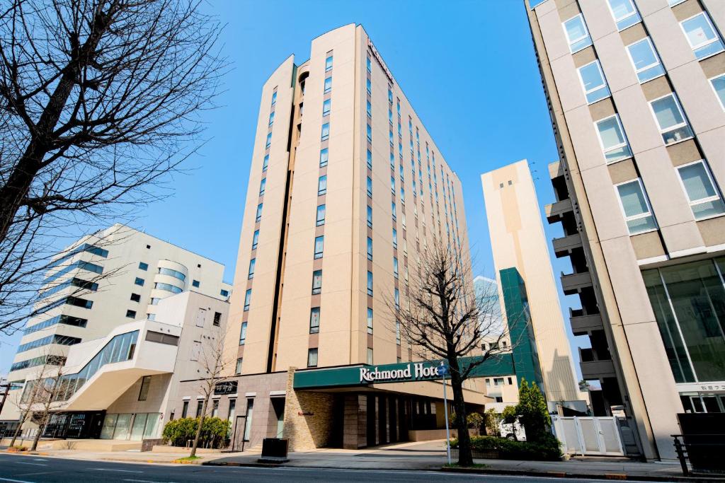 a tall building with a sign in front of it at Richmond Hotel Akita Ekimae in Akita
