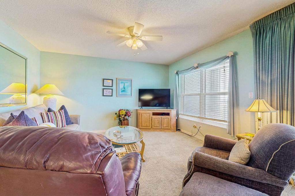 a living room with a couch and a tv at Beautiful beachfront condo with shared pool & beach access in Fort Walton Beach