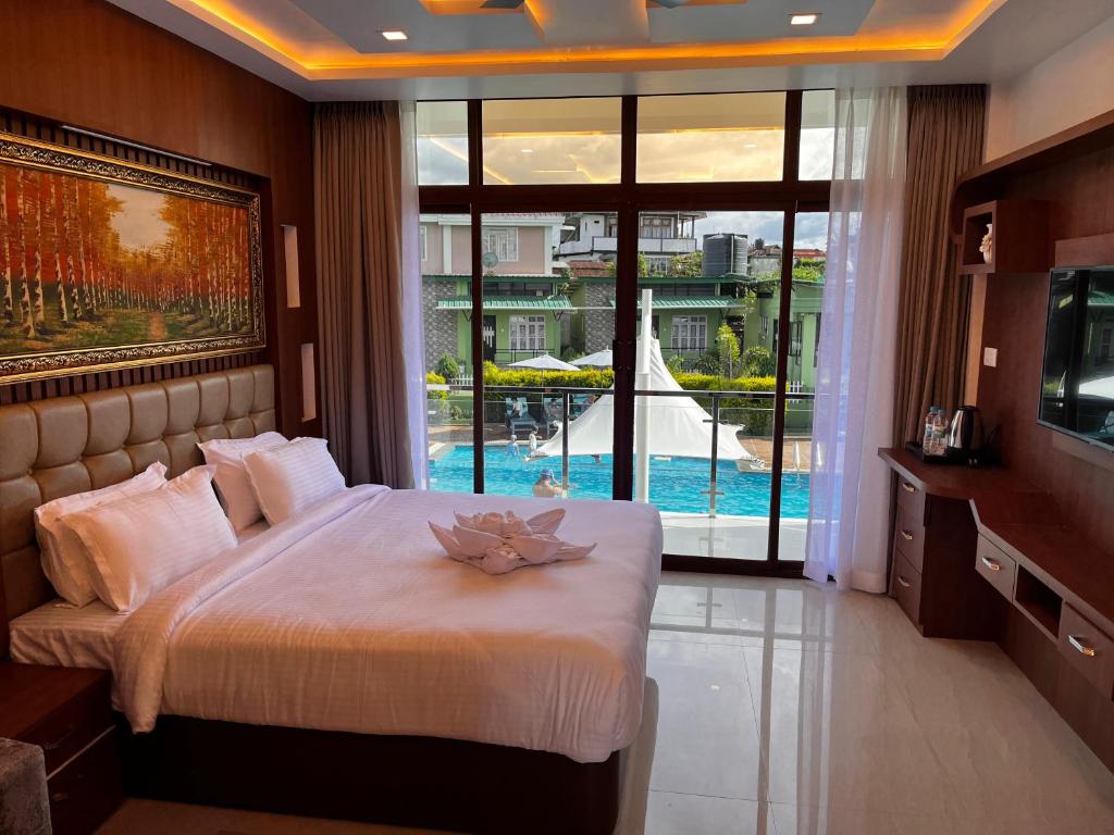 a bedroom with a bed with a view of a pool at Emmonlang Resort and Restaurant in Dingpasoh