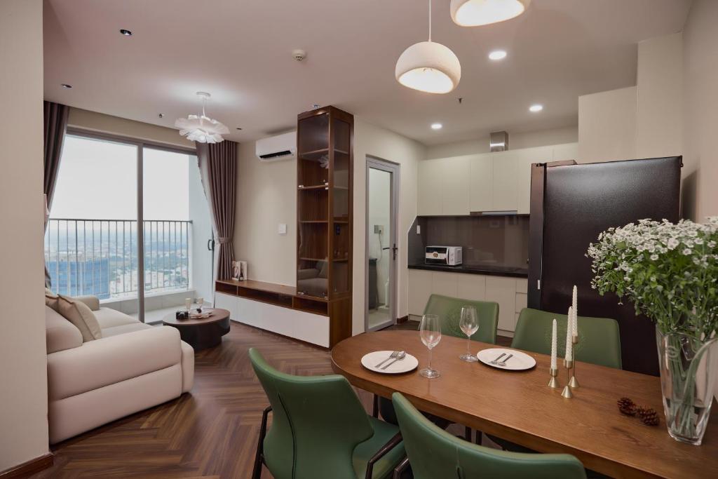 a living room with a table and green chairs at HongHome Happy One Central in Ga Phú Văn